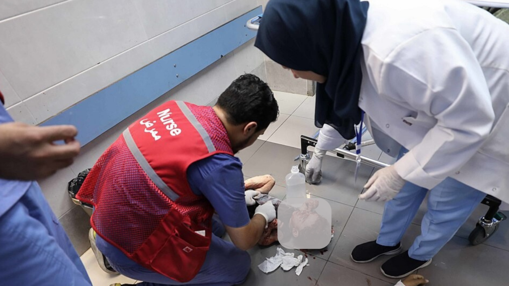 Un medico e un infermiere a Gaza soccorrono un bambino ferito da un'esplosione dopo un bombardamento israeliano